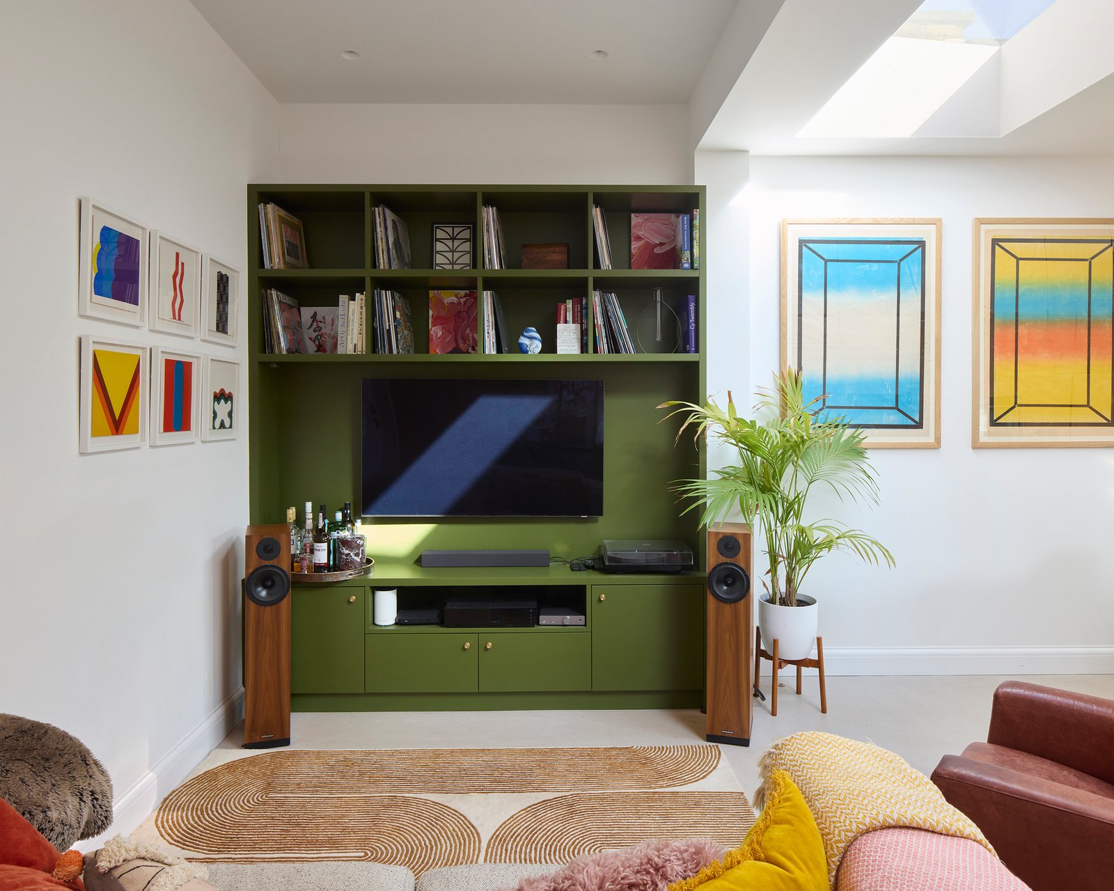 Contemporary living room with bespoke shelving, large glazed doors and garden views
