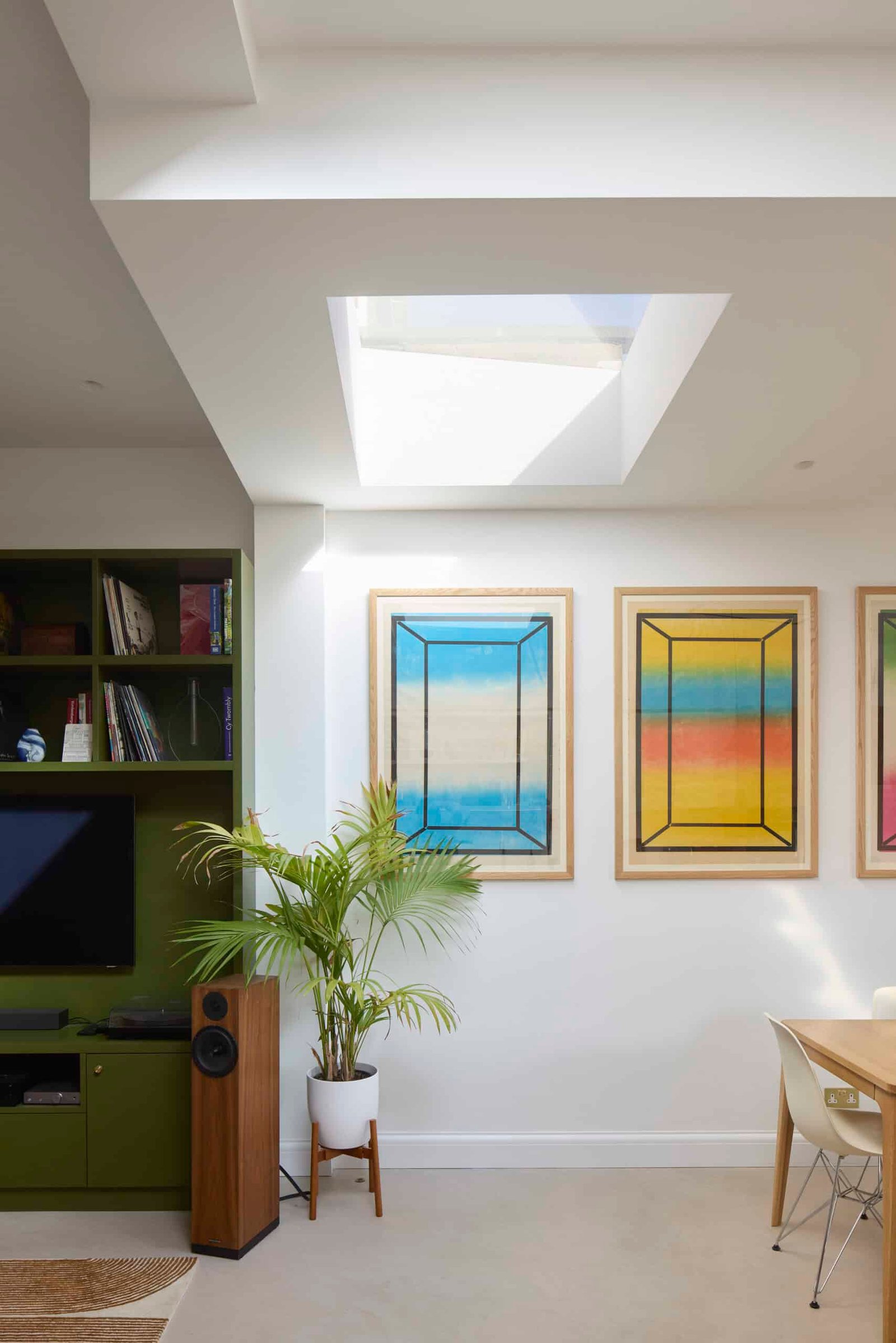 Contemporary living room with bespoke shelving, large glazed doors and garden views